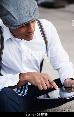 Portrait of Man Sitting on the Ground Using a Tablet, Mannheim, Baden-Wurttemberg, Germany Stock Photo