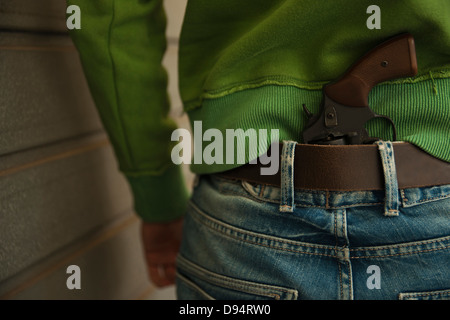 Close-up of Back of Young Man with Handgun Tucked into Waistband of Blue Jeans, Mannheim, Baden-Wurttemberg, Germany Stock Photo