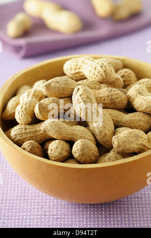 Close-up of Bowl of Peanuts on Purple Background, Studio Shot Stock Photo
