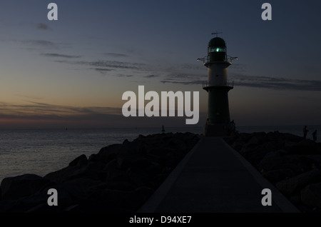 Starboard's fairway-lighthouse at an input in a bay Rostock (Germany) is against the sunset sky. Stock Photo