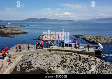 Passengers are disembarking from motor vessel Ullin of Staffa at Staffa pier in Scotland and making their way to Fingal's Cave Stock Photo