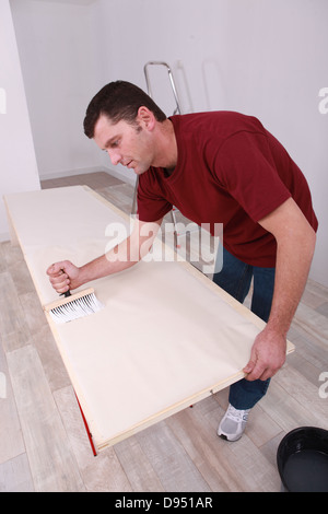 Man pasting wallpaper Stock Photo