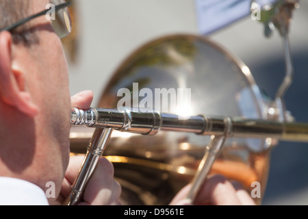 looking over shoulder of man playing trombone close up Stock Photo