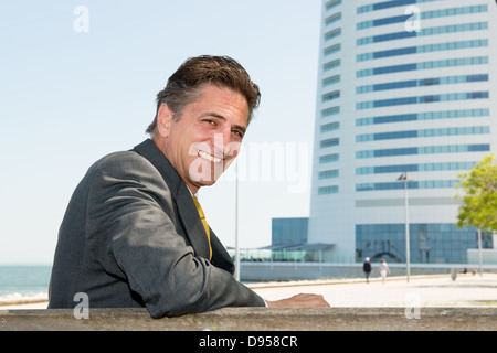 Businessman relaxing outdoors near the water Stock Photo