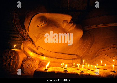 Candle offerings to 11th century reclining BUDDHA at SHINBINTHAHLYAUNG TEMPLE - BAGAN, MYANMAR Stock Photo