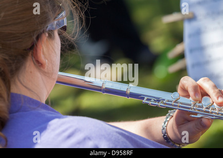 Llooking over shoulder of woman playing a flute. Stock Photo