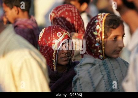 Tribal Rajasthani woman with traditional nose ring standing in the crowd of men, Rajasthan, India Stock Photo