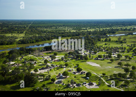 Boro village, Boro River, and Buffalo fence stretching into distance, Okavango Delta, Botswana, Africa- aerial Stock Photo