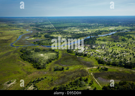 Buffalo fence (disease control fence) separating wildlife from domestic cattle, and Boro River, Okavango Delta, Botswana, Africa Stock Photo