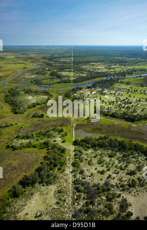 Buffalo fence (disease control fence) separating wildlife from domestic cattle, and Boro River, Okavango Delta, Botswana, Africa Stock Photo