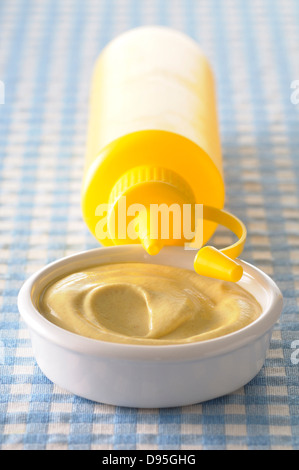 Close-up of Bowl of Mustard and Yellow Squeeze Bottle Stock Photo