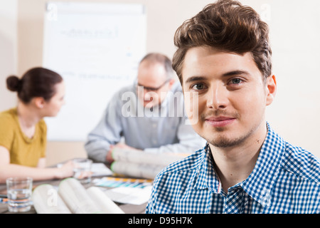 Portrait of Young Businessman with Colleagues Meeting in the Background Stock Photo