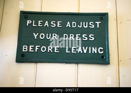 "Please adjust your dress before leaving" - a sign in the gents lavatory at the Bluebell Railway in East Sussex, UK. Stock Photo