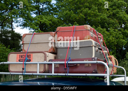 Old style fashioned luggage suitcases on car roof rack Stock Photo