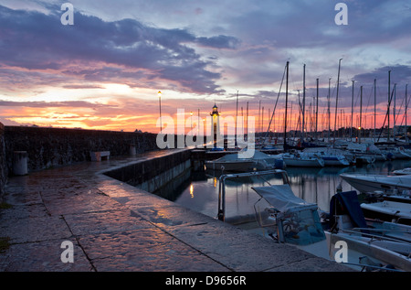 Desenzano Del Garda marina waterfront with the old Lighthouse in a very early morning beautiful sunrise. Stock Photo