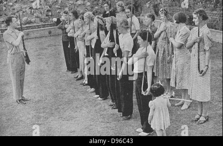 Members of the Women's Volunteer Defence Corps being trained in rifle drill:1940. Small arms were in short supply and only the instructor has a weapon, the women are improvising with walking sticks, umbrellas and even broom handles  World War II. Stock Photo