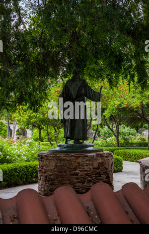 A statue of Father Junipero Serra holding an Indian boy in the garden at Mission San Fernando Rey de España in Los Angeles Stock Photo