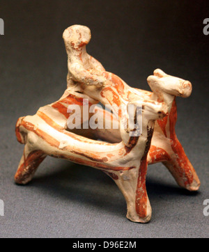 Terracotta group of a man in a two horse chariot Found in Tomb 4, Ialysos, Rhodes. The form is simplified: the two horses have only four legs between them and the chariot wheels are not represented, In the chariot stands the rider, holding a crude pair of reins. Stock Photo