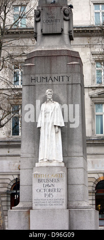 Memorial statue of Edith Cavell, British nurse and patriot. Set at Saint Martin's Place in London, England. Made of White marble against a tall granite cross. Made by Sir George Frampton and unveiled in 1920 Stock Photo