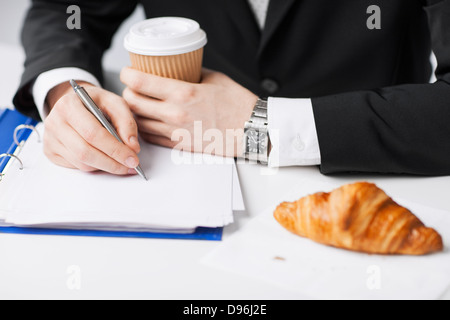 businessman with coffee writing something Stock Photo