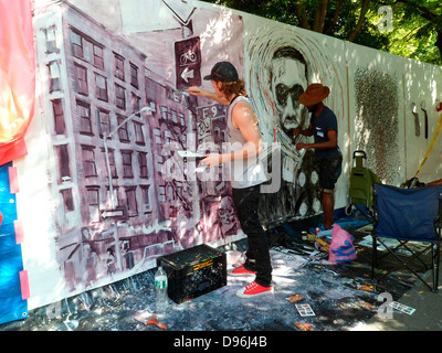 Artists work on their canvas' at the Howl! Festival's 'Art Around the Park' around Tompkins Square Park in NY's East Village Stock Photo