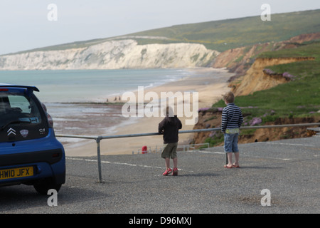 Compton Bay car park showing erosion and collapse. Children play near the edge despite the danger. Stock Photo