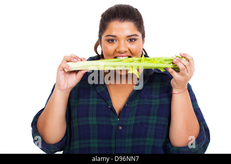 portrait of beautiful overweight woman biting on celery Stock Photo