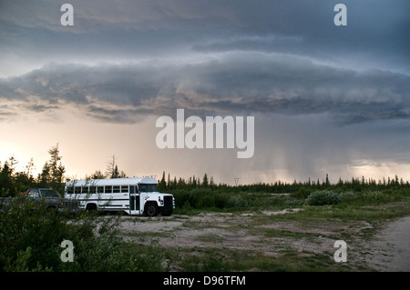 Dark clouds of a summer storm pour rain over the tundra near the town of Churchill, Manitoba, Canada. Stock Photo