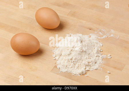 An Organic Brown Chicken Egg and white flour on a wooden board Stock Photo