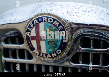 The Logo and Emblem of Alfa Romeo on the grille of an Old car of the company with raindrops Stock Photo
