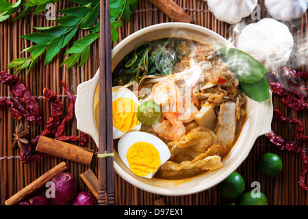 Prawn mee, prawn noodles. Popular Malaysian food spicy fresh cooked har mee in clay pot with hot steam. Asian cuisine. Stock Photo