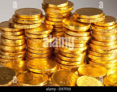 A stack of gold chocolate coins wrapped in a golden foil Stock Photo