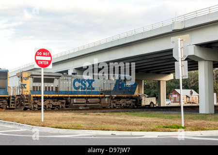 CSX engine 7735 pulling a freight train through a railroad crossing and overpass in Hawthorne, Florida. Stock Photo