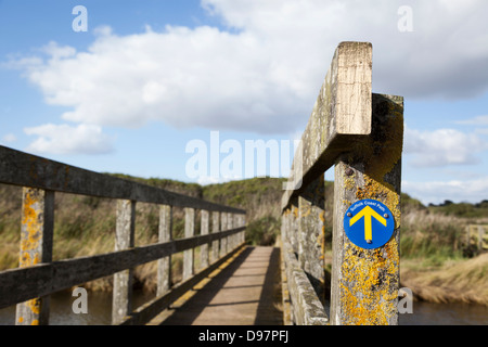 A waymarker on a footbridge on the Suffolk Coast Path, a long-distance footpath along the Suffolk Heritage Coast in England. Stock Photo