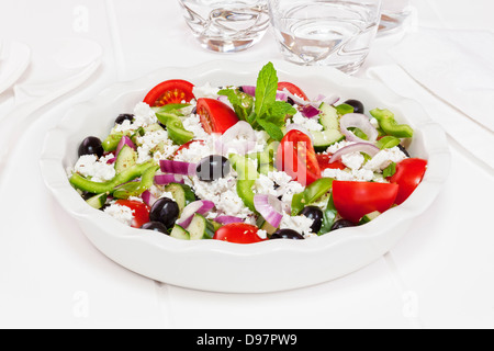 Greek salad, popular salad made from tomatoes, green pepper, cucumber, black olives, mint, oregano and feta cheese. Stock Photo