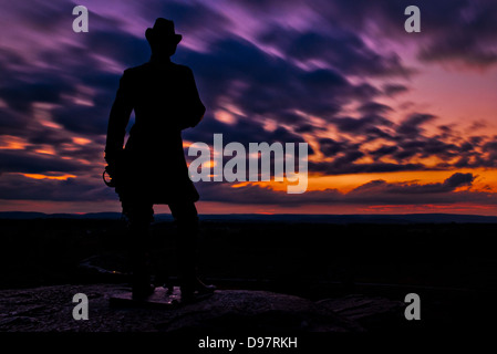 Clouds move behind a statue in a long exposure taken after sunset from Little Round Top in Gettysburg, Pennsylvania. Stock Photo