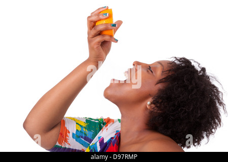Overweight young black woman drinking orange juice , isolated on white background - African people Stock Photo