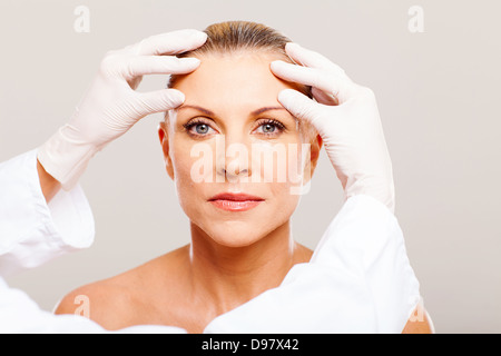 doctor doing skin check on middle woman before cosmetic surgery Stock Photo