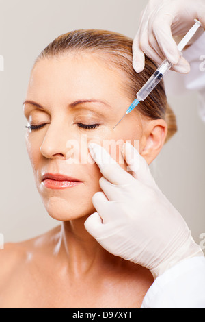 senior woman receiving plastic surgery injection on her face Stock Photo