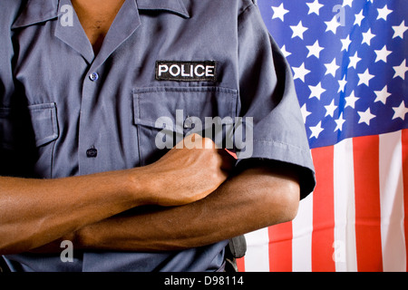 African American policeman standing in front of USA flag Stock Photo
