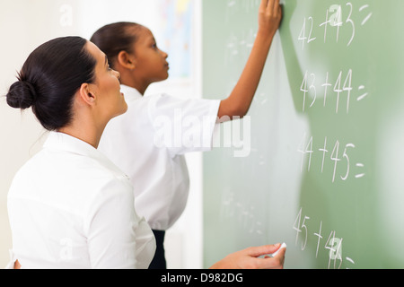 primary school maths teacher teaching student in classroom Stock Photo