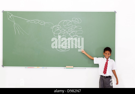 funny elementary schoolboy flying a impossible kite drawn on chalkboard Stock Photo