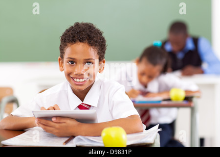 primary school boy using tablet computer in classroom Stock Photo