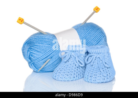 Baby boy knitted booties with blue wool and knitting needles, isolated on a white background. Stock Photo