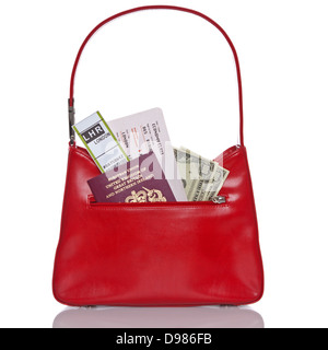 Ladies handbag with Passport, airline ticket, currency and baggage reclaim label. Isolated on a white background. Stock Photo