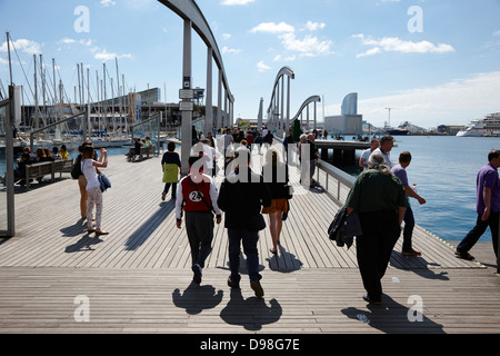 people walking along rambla de mar walkway in the old port of barcelona catalonia spain Stock Photo