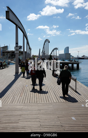 people walking along rambla de mar walkway in the old port of barcelona catalonia spain Stock Photo