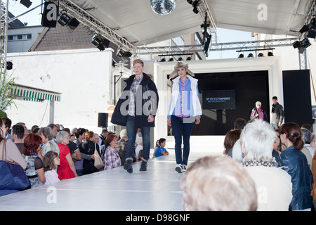 Male and female fashion models being watched by the public on an outdoor catwalk at the open-air event of Krefeld Fashion World in 2012 Stock Photo