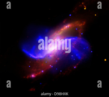 In this composite image of spiral galaxy M106 (NGC 4258), optical data from the Digitized Sky Survey is shown as yellow, radio data from the Very Large Array appears as purple, X-ray data from Chandra is coded blue, and infrared data from the Spitzer Space Telescope appears red. Two anomalous arms, which aren't visible at optical wavelengths, appear as purple and blue emission. Stock Photo