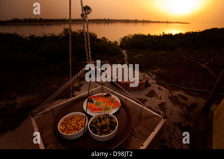 Snacks being delivered to join sundowner drinks on the top of a Baobab tree. Stock Photo
